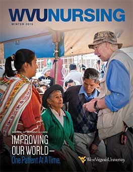 The cover page features a photo of two women and a man from a local community in Bolivia speaking with Francis Boyle, an older white man. At the bottom is the text “School of Nursing Alumni: Improving Our World—One Patient at a Time,” alongsie the West Virginia University wordmark.
