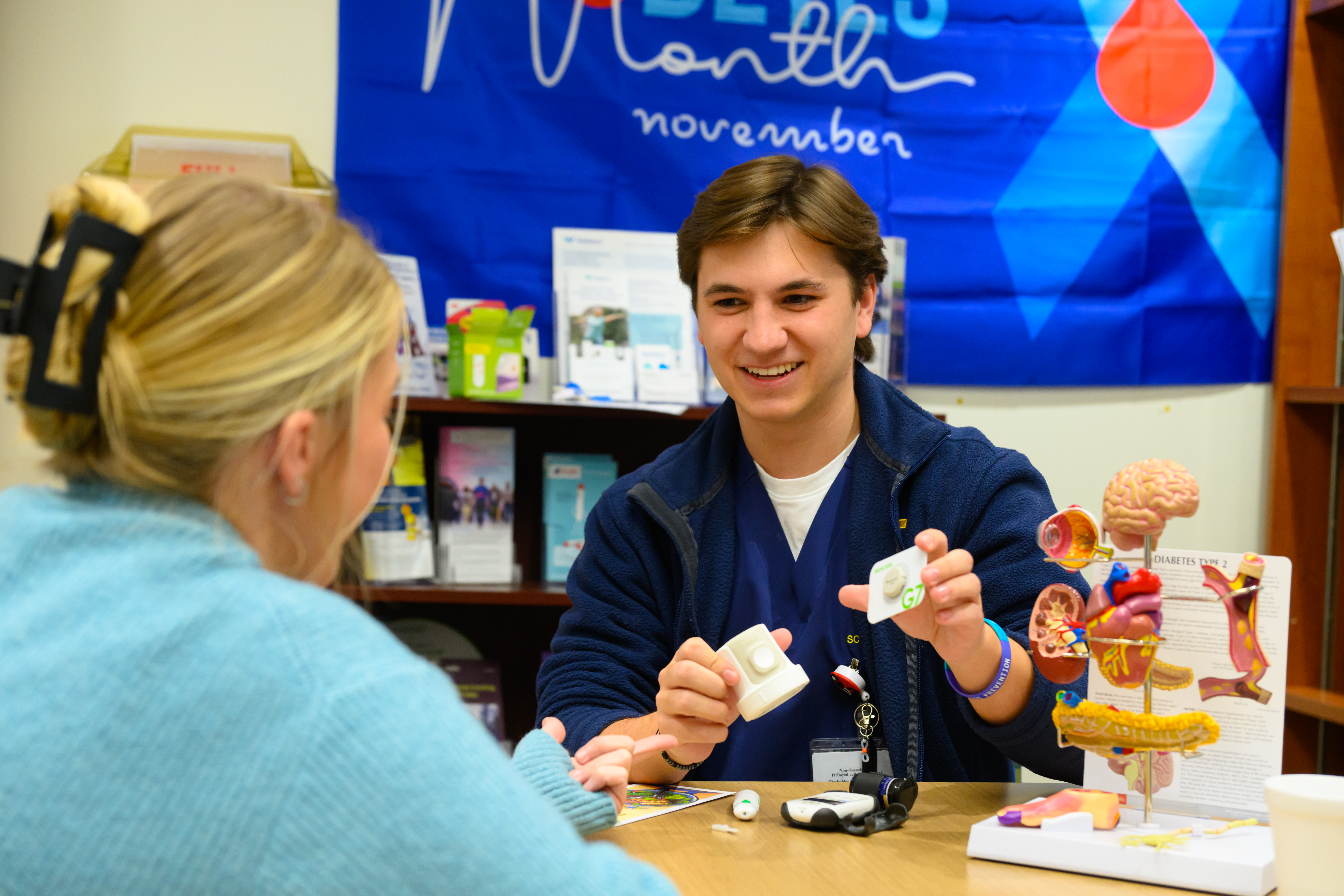 A student nurse shows a patient information about diabetes.