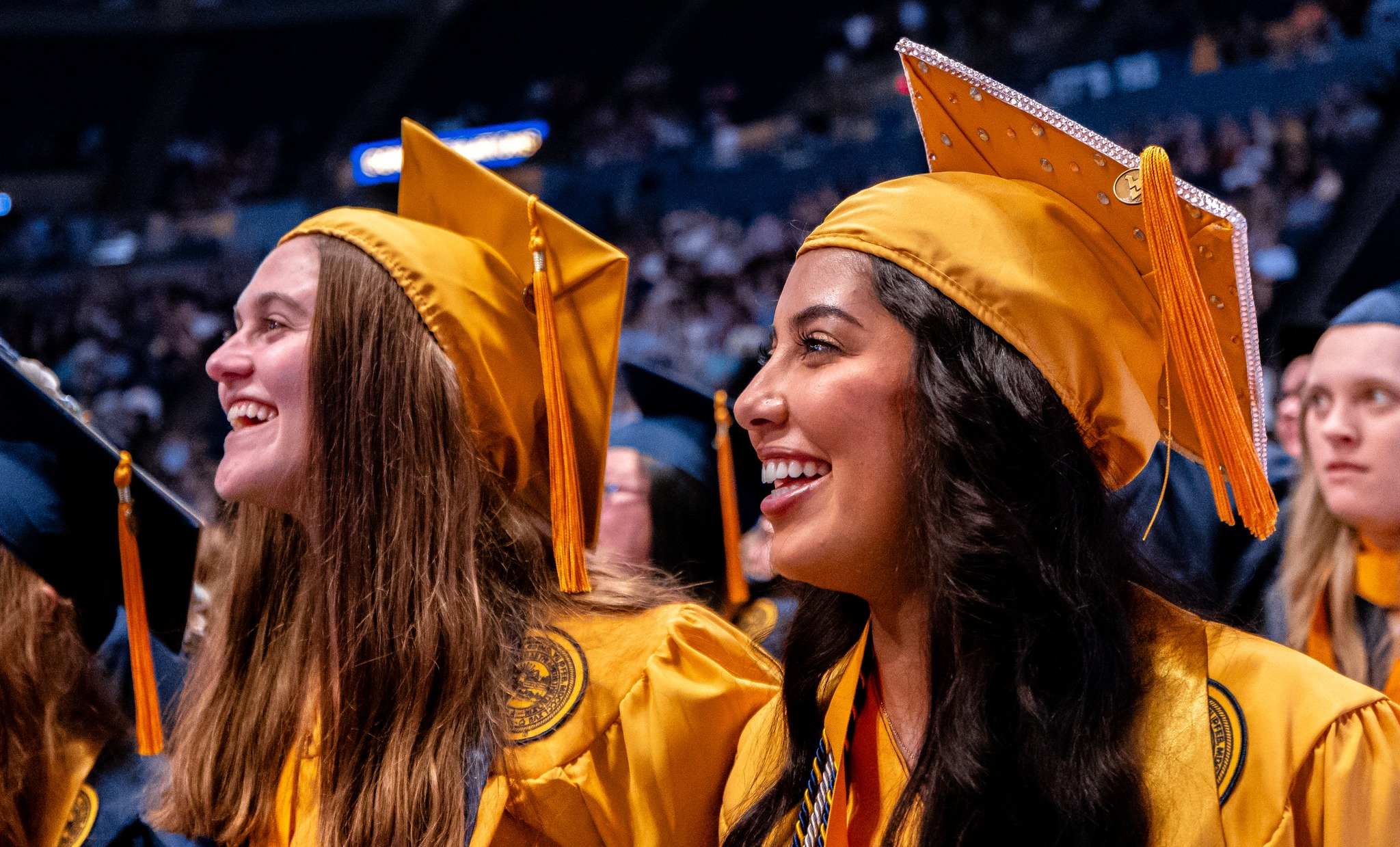Two nursing students smile during commencement.