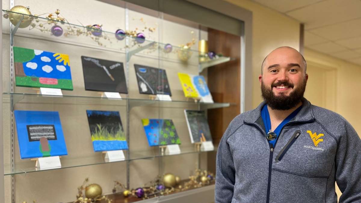 Faculty member Brad Phillips in front of an art display.