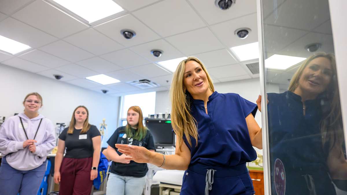 Prospective nursing students hear from a faculty member in a simulation lab.