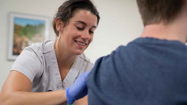 A nursing student administers a flu shot during a community clinic.
